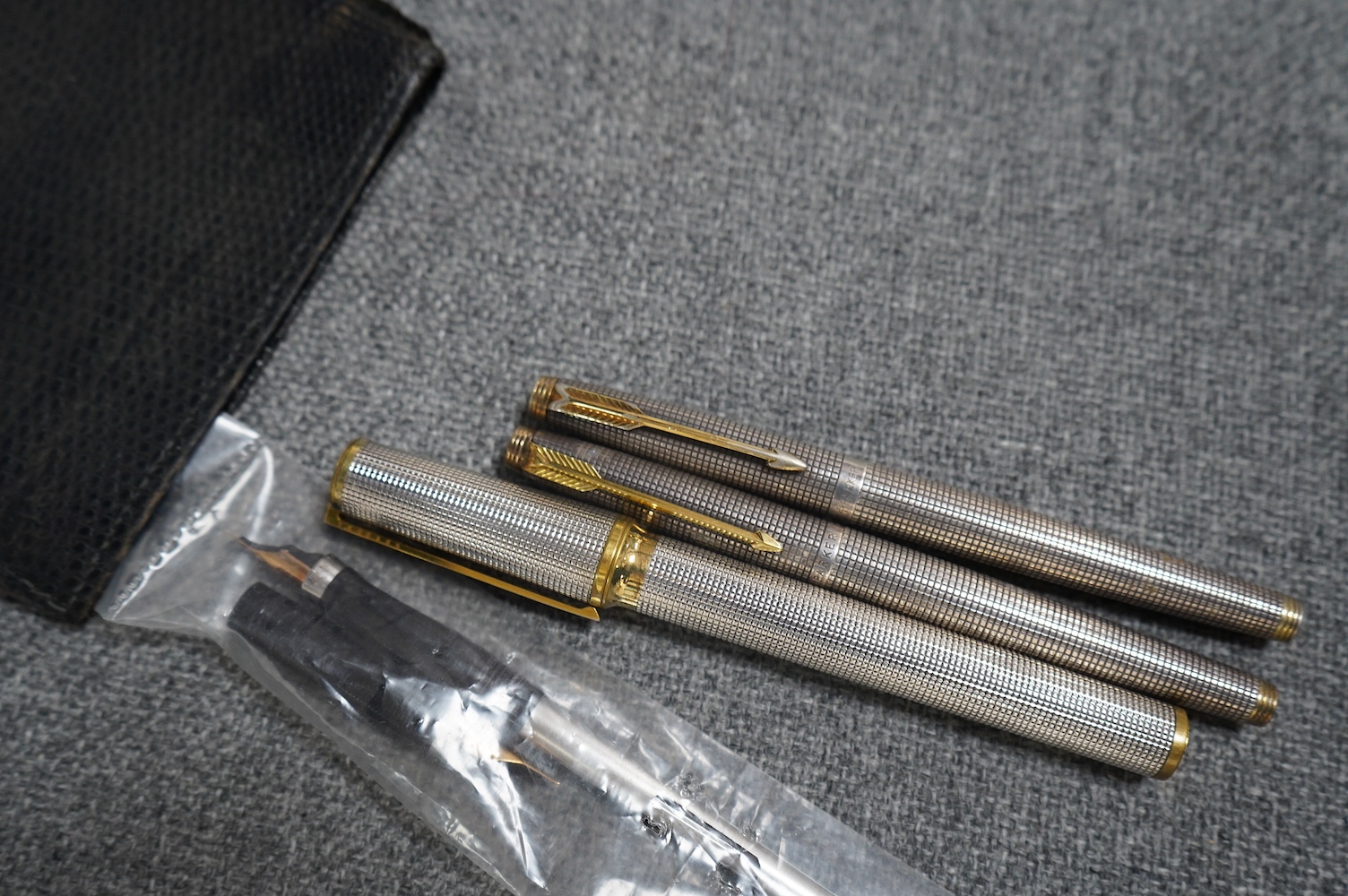 A collection of pens comprising two Sterling Parker fountain pens, one with 14k gold nib, a silver Yard-O-Lead pen, a lizard skin wallet and a Dupont fountain pen. Condition - wallet worn, pens not tested with ink for wo